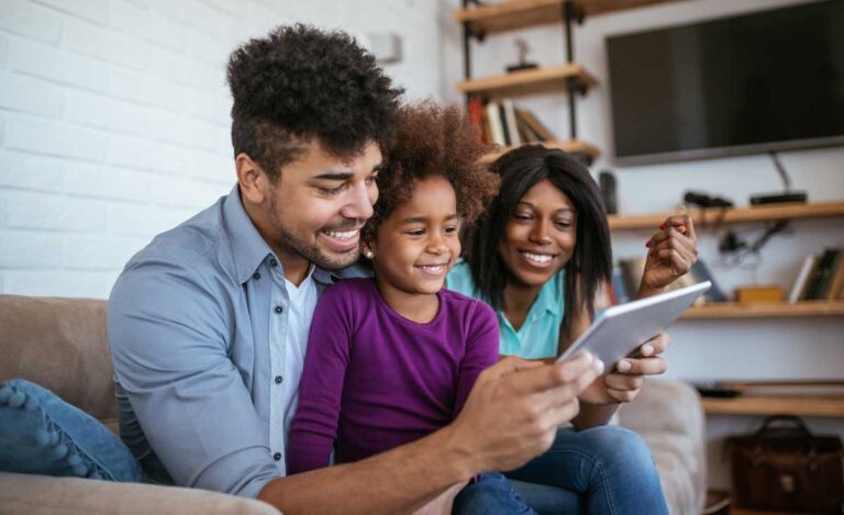 family on couch looking at tablet